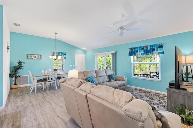 living room featuring visible vents, light wood finished floors, baseboards, lofted ceiling, and ceiling fan with notable chandelier
