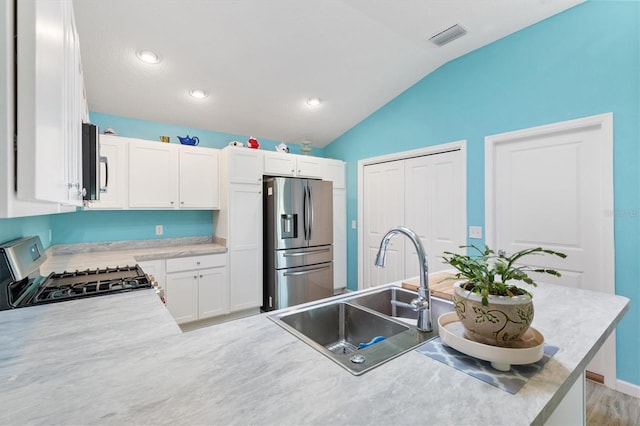kitchen featuring visible vents, light countertops, appliances with stainless steel finishes, white cabinetry, and a sink