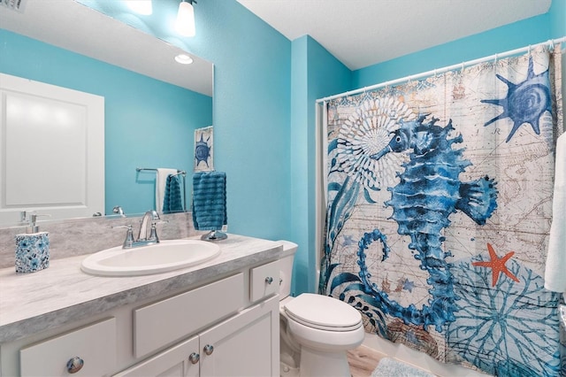 bathroom with a shower with shower curtain, toilet, and vanity
