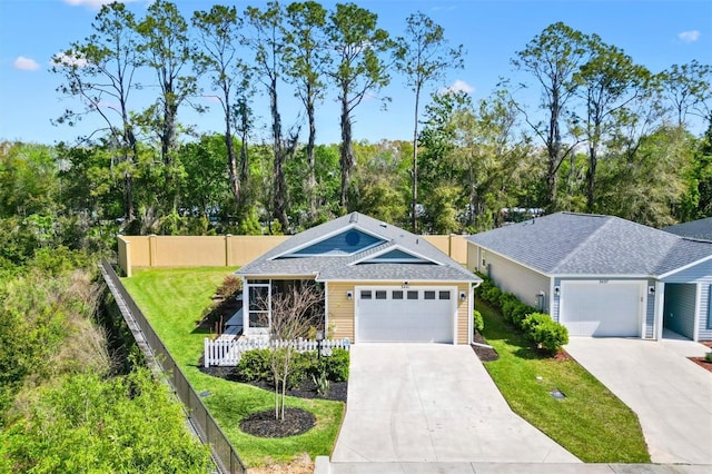 ranch-style house featuring a garage, concrete driveway, a front lawn, and fence