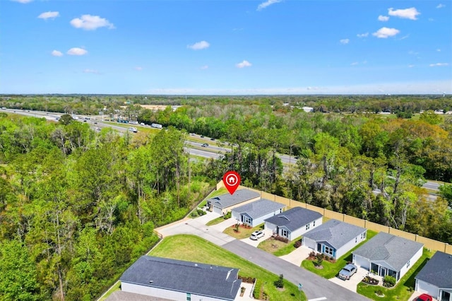 drone / aerial view with a wooded view and a residential view