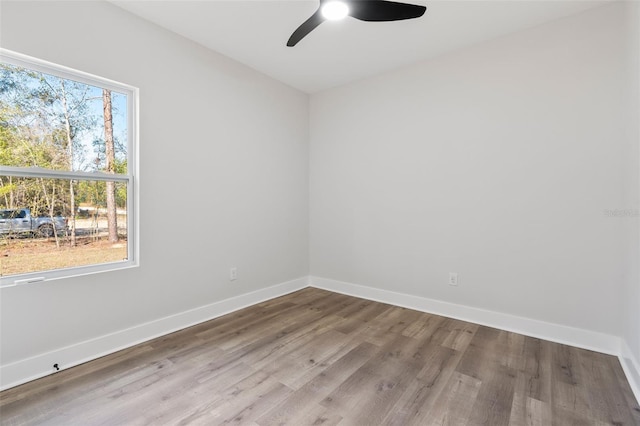 unfurnished room with wood finished floors, baseboards, and ceiling fan