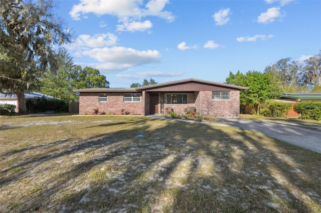 single story home featuring a front yard and brick siding