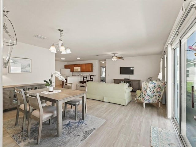 dining space with recessed lighting, light wood-type flooring, visible vents, and ceiling fan with notable chandelier