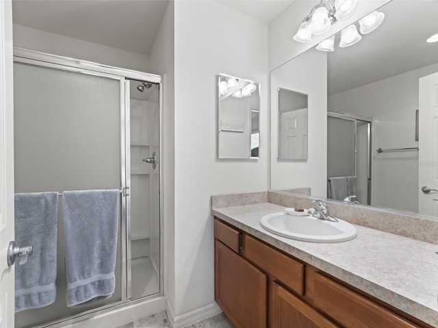 full bathroom with a shower stall, vanity, and baseboards