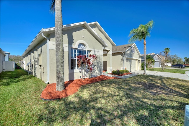 view of front facade with stucco siding, a front lawn, fence, concrete driveway, and an attached garage