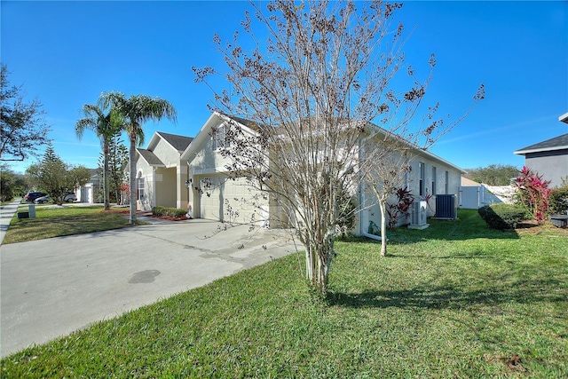 view of front of home featuring an attached garage, a front yard, driveway, and central AC