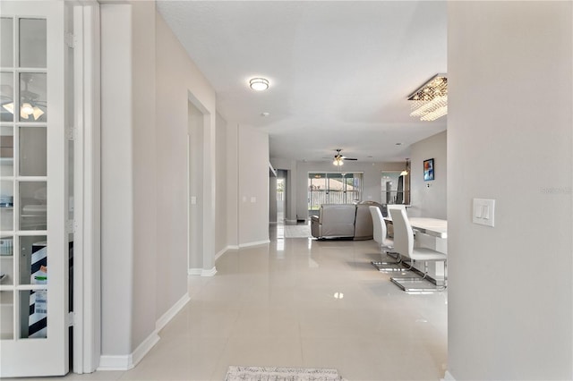 corridor with light tile patterned flooring and baseboards