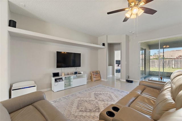 living area featuring baseboards and a ceiling fan