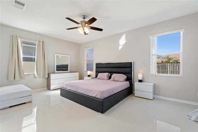 bedroom featuring tile patterned floors, visible vents, baseboards, and ceiling fan