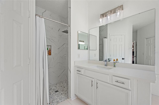 full bathroom featuring a marble finish shower and vanity