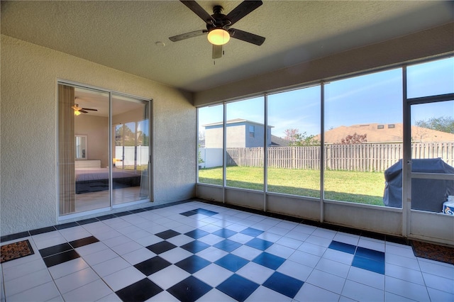 unfurnished sunroom featuring a ceiling fan