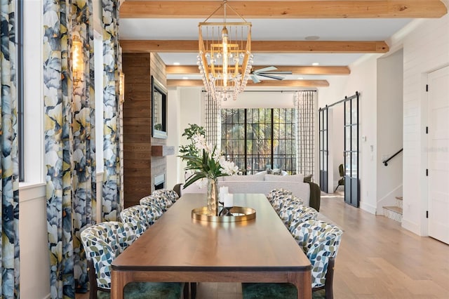 dining space featuring beam ceiling, wood finished floors, an inviting chandelier, baseboards, and stairs