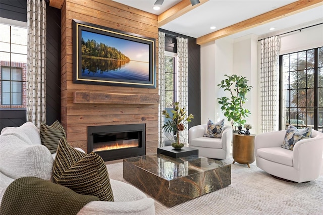 carpeted living area featuring beam ceiling, a glass covered fireplace, and recessed lighting