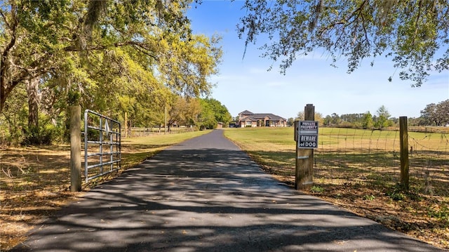 view of road with aphalt driveway and a gated entry