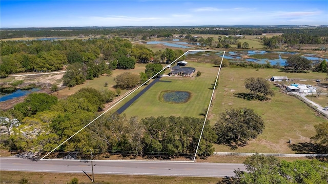 aerial view featuring a forest view and a water view