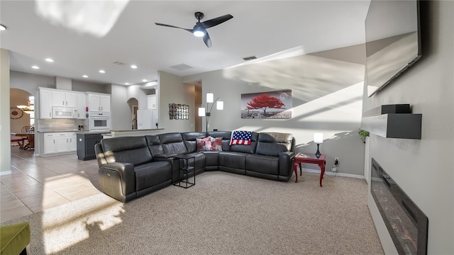 living room featuring light tile patterned floors, a ceiling fan, visible vents, recessed lighting, and arched walkways