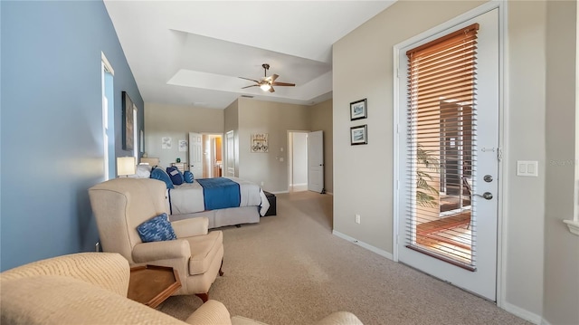 bedroom with access to exterior, ceiling fan, baseboards, a tray ceiling, and carpet flooring