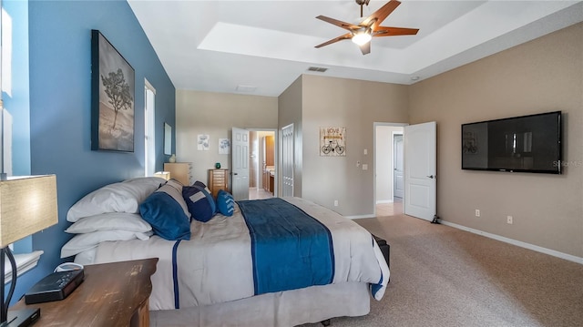 carpeted bedroom with visible vents, ceiling fan, a raised ceiling, and baseboards