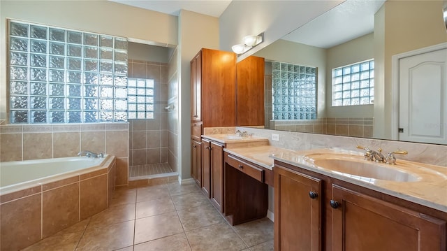 full bath with tile patterned flooring, walk in shower, double vanity, a bath, and a sink