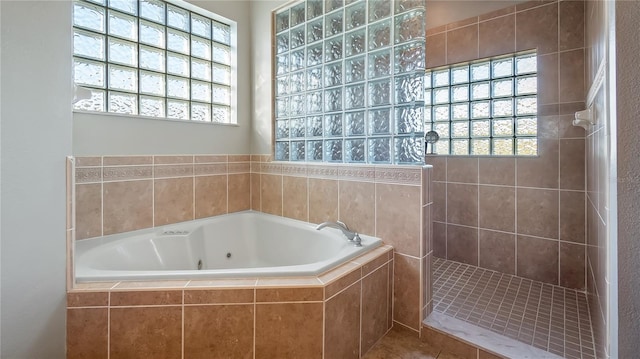 full bath featuring a wealth of natural light, a walk in shower, and a jetted tub