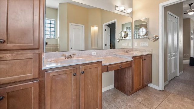 full bath featuring tile patterned floors, double vanity, baseboards, and a sink