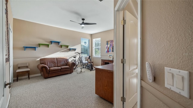 interior space with baseboards, ceiling fan, and a textured wall