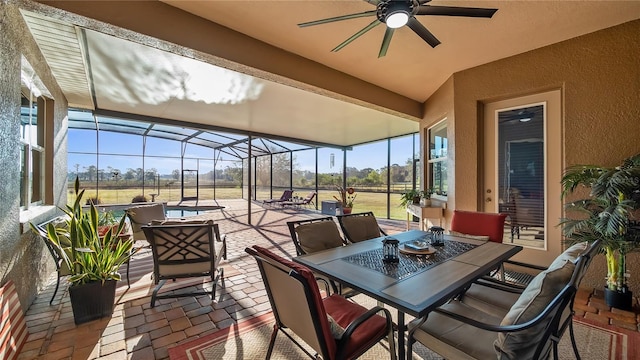 view of patio / terrace featuring outdoor dining space, a lanai, and ceiling fan