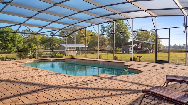 outdoor pool featuring glass enclosure, a lawn, and a patio area