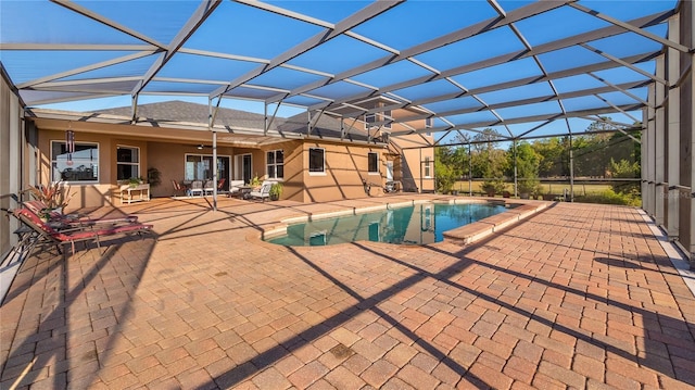 outdoor pool with a lanai and a patio area