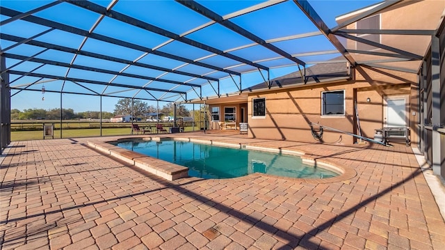 outdoor pool featuring glass enclosure and a patio