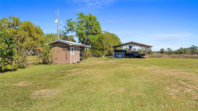 view of yard featuring a carport, a storage unit, and an outbuilding