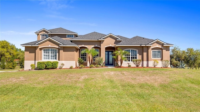 view of front facade with a front yard and stucco siding