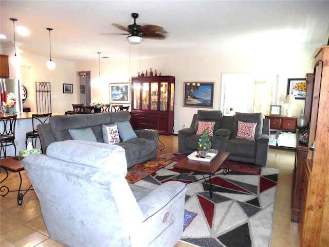 living area featuring light tile patterned floors, a ceiling fan, and crown molding