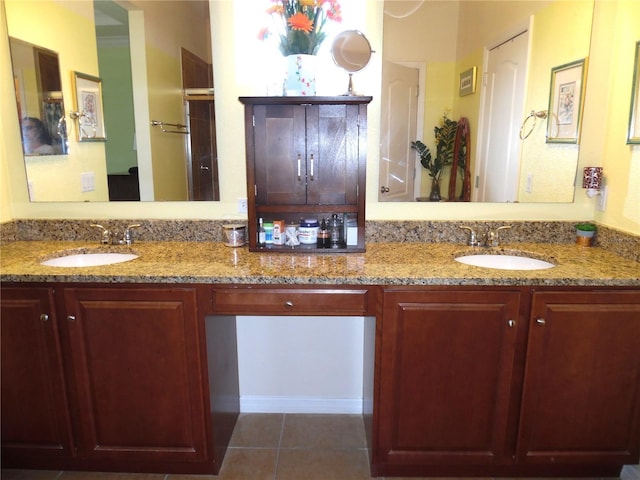 bathroom with a sink, double vanity, and tile patterned flooring