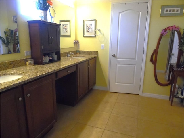 bathroom with tile patterned flooring, baseboards, and a sink