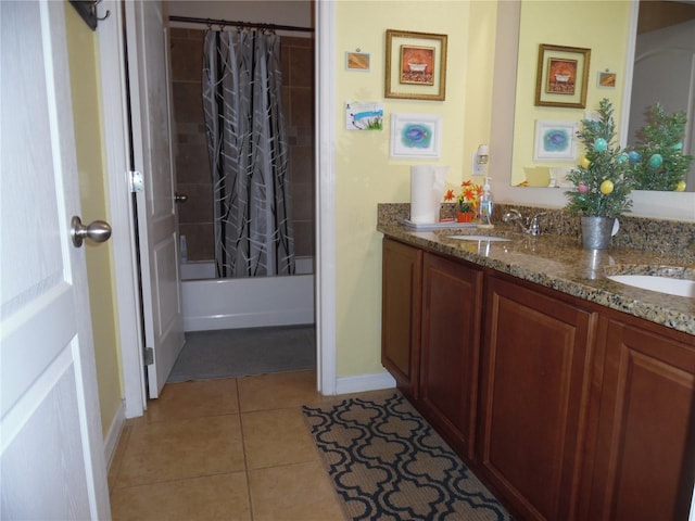 full bathroom featuring tile patterned floors, double vanity, shower / bath combo with shower curtain, and a sink