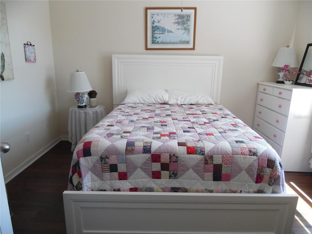 bedroom featuring baseboards and dark wood-type flooring