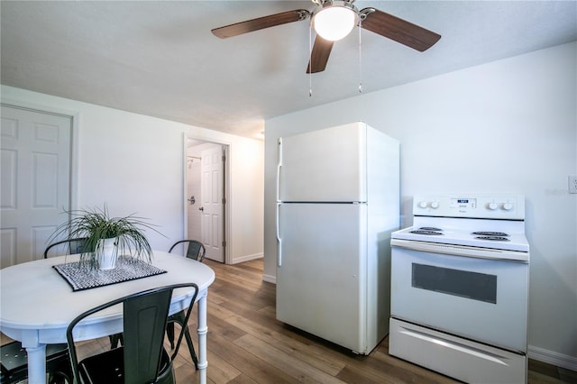 kitchen featuring white appliances, baseboards, a ceiling fan, and wood finished floors