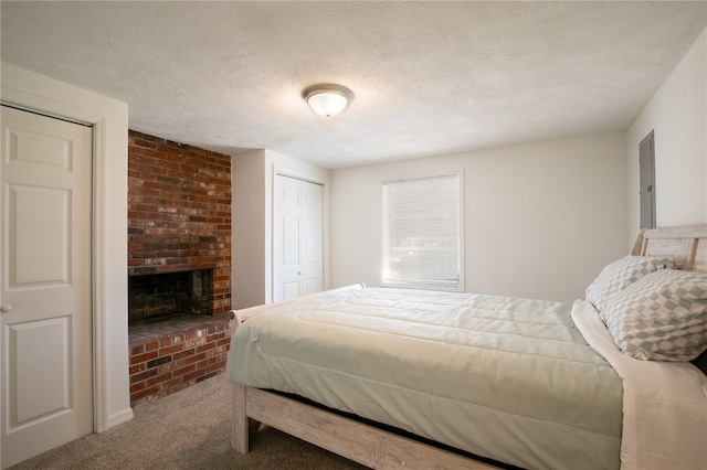 carpeted bedroom featuring a closet, a fireplace, and a textured ceiling