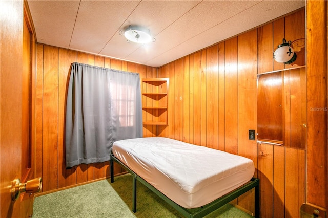 bedroom with carpet, baseboards, and wood walls