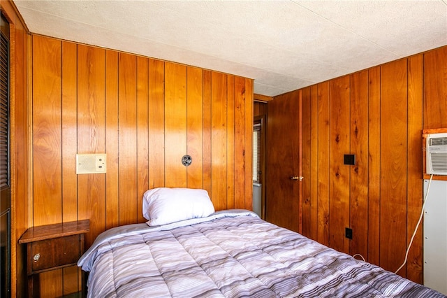 bedroom featuring a closet, wood walls, and an AC wall unit