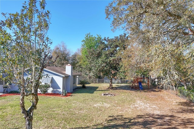 view of yard with a fenced backyard and a playground