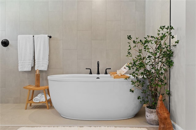 full bath featuring tile walls and a freestanding tub