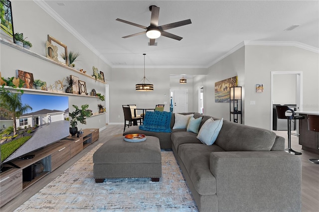 living area with visible vents, baseboards, a ceiling fan, and ornamental molding