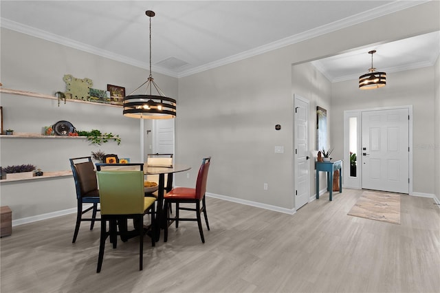 dining space featuring baseboards, wood finished floors, a chandelier, and crown molding