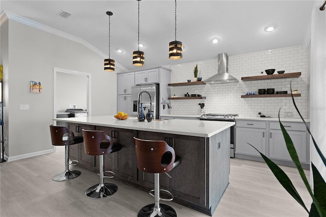 kitchen with visible vents, vaulted ceiling, appliances with stainless steel finishes, wall chimney exhaust hood, and open shelves