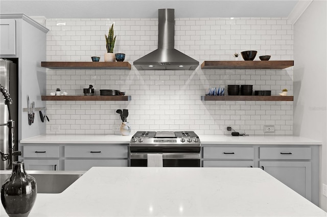 kitchen with open shelves, appliances with stainless steel finishes, gray cabinetry, and wall chimney range hood