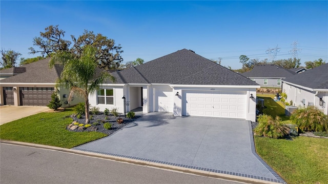 view of front of property with stucco siding, driveway, a front yard, a shingled roof, and a garage