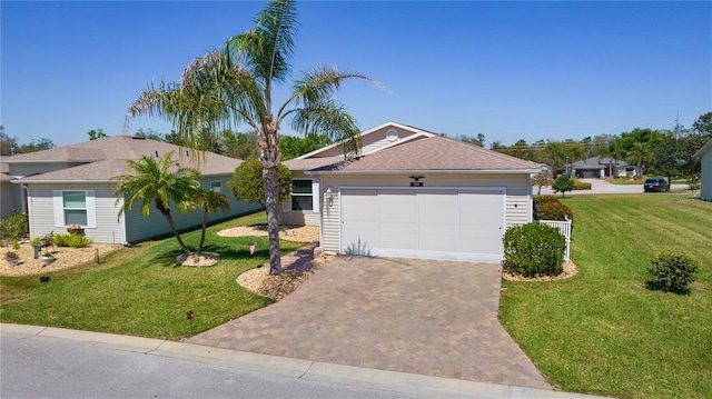 view of front of property featuring a front yard, decorative driveway, and roof with shingles